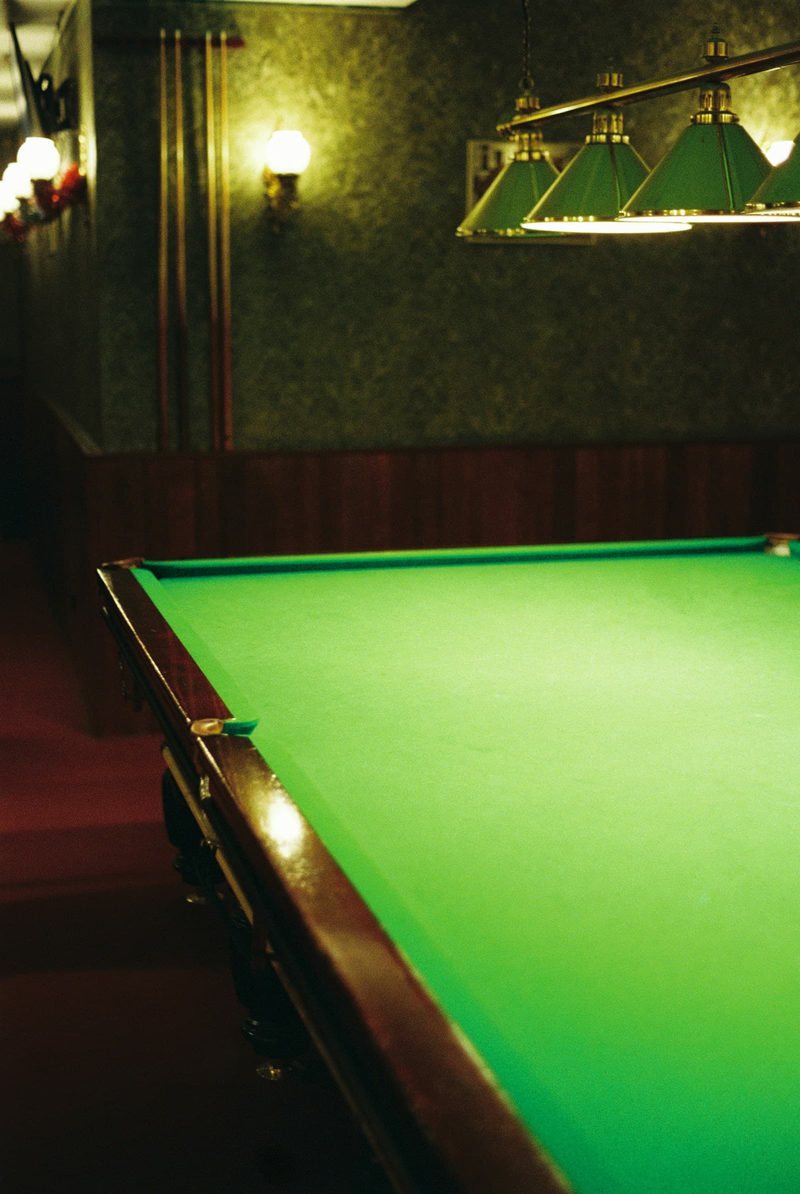 Atmospheric snooker room beneath overhead lights